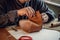 An experienced tanner sews a clasp for a leather product with stitches