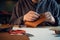 An experienced tanner sews a clasp for a leather product with stitches