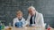 Experienced teacher teaching little kid how to conduct chemistry experiment in lab
