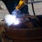 An experienced welder at work. Preparation and welding process of cast iron furnace. Selection focus. Shallow depth of field