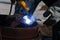 An experienced welder at work. Preparation and welding process of cast iron furnace. Selection focus. Shallow depth of field