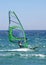 Experienced windsurfer speeding along sunny blue sea giving a real feeling of motion.