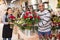 Experienced woman florist helping male client to choose flowers in shop