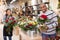Experienced woman florist helping male client to choose flowers in shop
