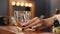 Experienced woman sommelier shaking a glass with whiskey and inhaling alcohol aroma. Female hand moves glass with