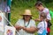 Experienced woman teach girls to plait handmade straw hats, traditional ancient craft fashion