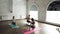 Experienced yoga teacher is demonstrating balancing pose to two female students on group practice in wellness center