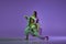 Experimental dance. Two young girl in motion, action  over purple background. Emotions, love, style, youth