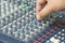 An expert adjusting audio mixing console