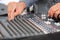 An expert adjusting audio mixing console