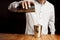 Expert barman making delicious cocktail on a wooden bar counter