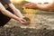 Expert hand of farmer pouring good soil