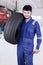 Expert mechanic carrying a tire in workshop