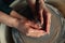 Expert potter assists child hands to work on pottery wheel