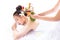 Expert or professional of massage of aromatherapy use herbal ball for massaging a beautiful customerâ€™s back with warm herbal ba