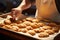 Expertly balancing, a skilled cook carries a tray of piping hot, delectable cookies