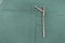 explanted femoral nail with locking screw lies on a green surgical drape