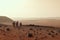 exploration team on the surface of mars, with distant view of the red planet in the background