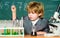 Explore biological molecules. Toddler genius baby. Boy near microscope and test tubes in school classroom. Technology