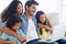 Exploring online together. a smiling family sitting on the sofa and using a laptop.