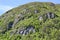 Exposed bedrock and lush forest growing along side of mountain at Bonne Bay