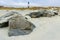 Exposed Jetty Boulders on North Beach With Historic Tybee Island Light Station