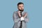 Expressing rejection. Serious bearded entrepreneur in formalwear showing STOP gesture on blue studio background