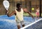 Expressive african american man playing paddle tennis on indoor court