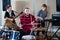 Expressive drummer with his bandmates practicing in rehearsal room