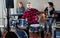 Expressive drummer with his bandmates practicing in rehearsal room