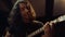 Expressive man playing guitar in studio. Guitarist gesticulating in hall.