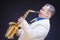 Expressive Mature Caucasian Male Saxophone Player Posing in White Suite