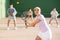 Expressive resolved fit girl playing frontenis ball friendly match on court