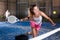 Expressive resolved girl playing paddle ball on closed court