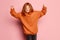 Expressive teen girl, modern kid with long red hair and freckles looking at camera isolated over pink background