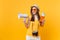 Expressive tourist woman in summer casual clothes hat holding megaphone passport tickets isolated on yellow orange