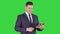 Expressive young businessman with tablet presenting something swiping on a Green Screen, Chroma Key.