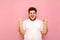 Expressive young man with an overweight and white t-shirt shows a heavy metal gesture and looks into the camera with a smile on