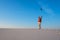 Expressive young woman, blonde jumps, with open arms, in the desert