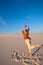 Expressive young woman, blonde runs through the desert