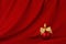 Exquisite christmas background - red ball with golden ribbon on deep red silk curtain with smooth waves, copy space. New year.