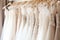 Exquisite display of beautiful white bridal dresses elegantly hanging on hangers in a boutique salon