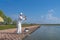 Exquisite fishing. Fisherman in white suit catch fish by spinning rod at trout area lake