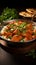 Exquisite fusion Indian butter chicken in black bowl on rustic wooden table