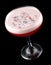 Exquisite original cocktail, decorated with colorful grains. On dark background