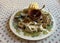 Exquisite plate with vegan cheeses with walnuts and sauce on tablecloth in kitchen