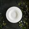 Exquisite serving white restaurant plate template on natural dark stone
