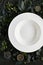 Exquisite serving white restaurant plate template on natural dark stone and leaves background