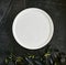 Exquisite serving white restaurant plate template on natural dark stone and leaves background