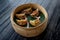 Exquisite traditional Asian Jiaozi of cochinita pibil and pickled onions inside on a wooden bowl